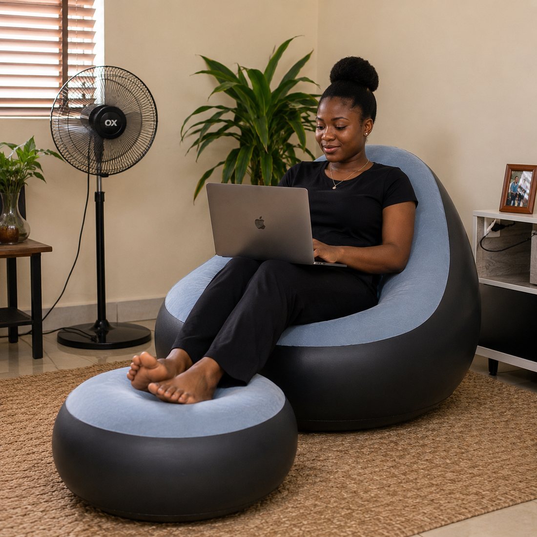 Woman working on a laptop in the air sofa with ottoman