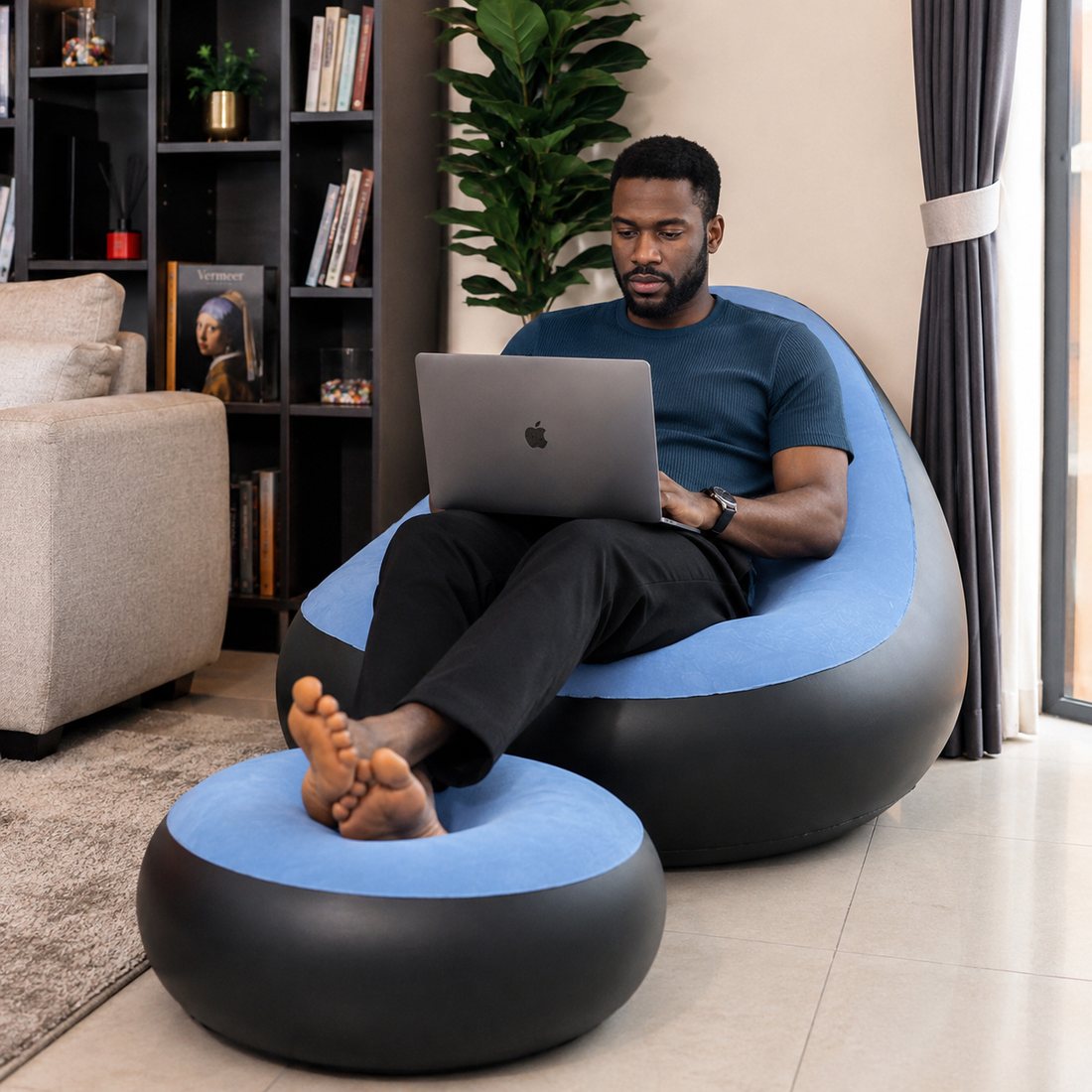 Man working on a laptop in the blue air sofa